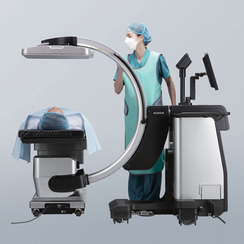 FDR Cross in fluoroscopy mode over a draped patient with a surgical technologist at the C-arm