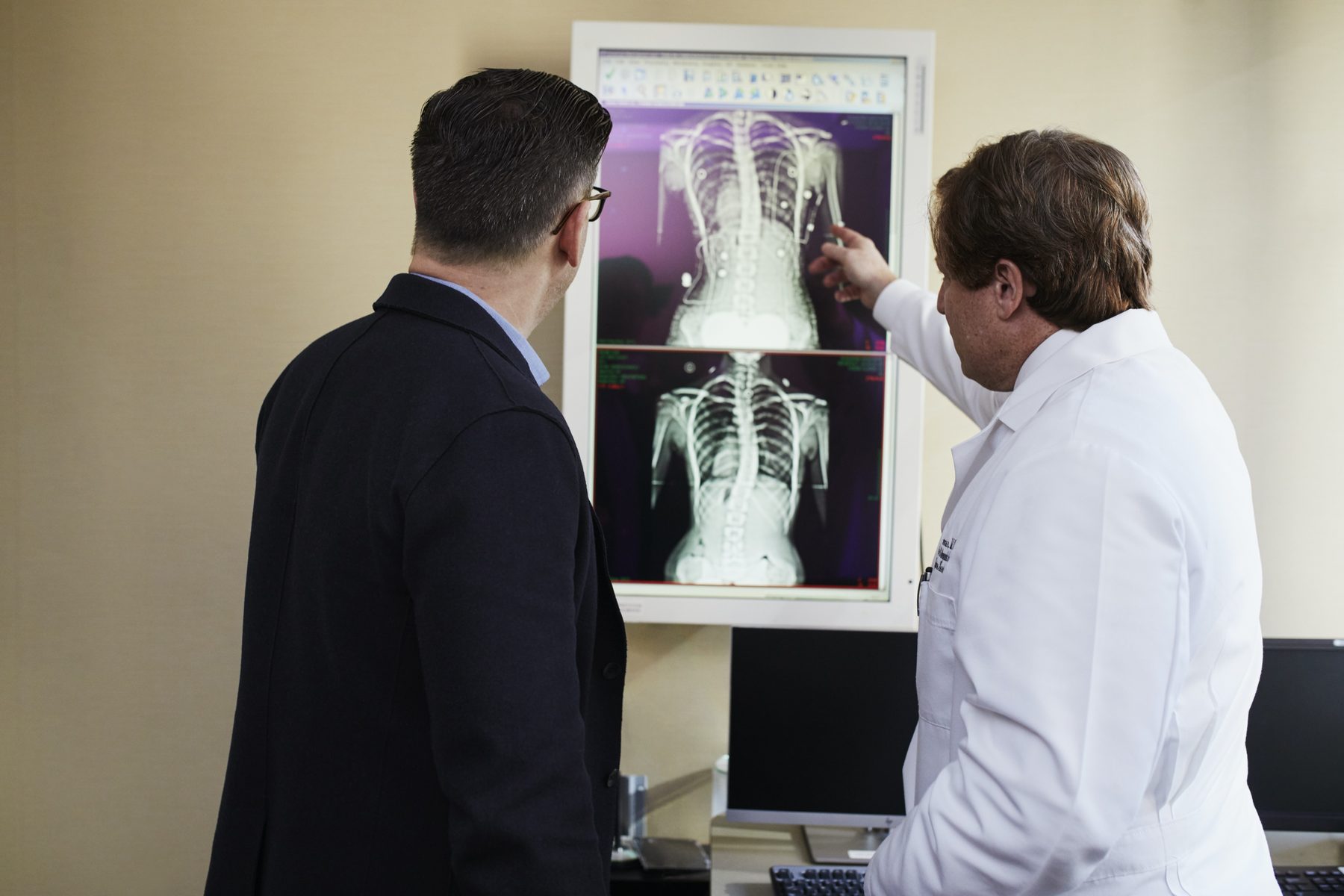 Physician reviewing spine radiographs with a colleague